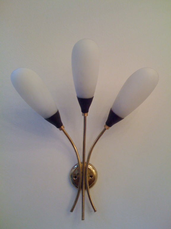 A great pair of 1950's three light wall lamps with brass fixtures and milk glass shades.