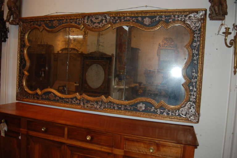 Exceptional carved, gilded and silvered mirror with original glass.