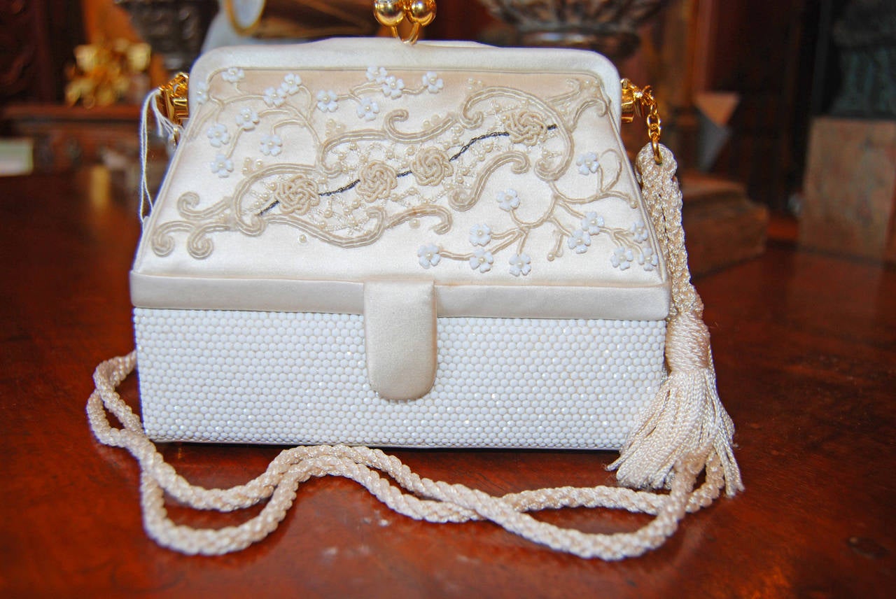 Intricately Embroidered Silk with Seed Pearls , White Crystals and Tasseled Strap.Silk Coin Purse and Signed Comb are included in this stunning purse.