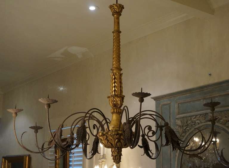 Expansive 18th century beautifully carved eight-light gilt wood and iron chandelier from Genoa. New US wiring.  Maison de Provence advises that all electrical wiring should be inspected by your electrician before installation since transport may