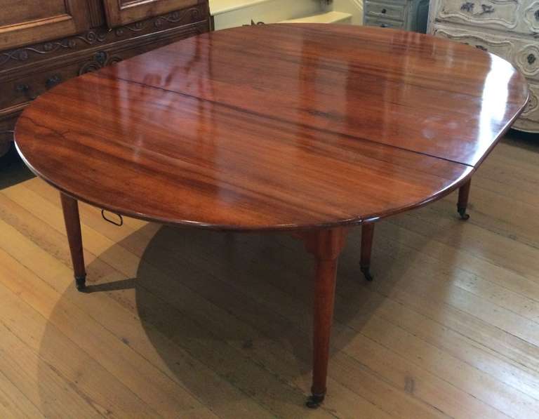 Beautifully restored 19th C Louis XVI Style Drop leaf Extension Dining Table in Walnut. Recessed apron allows no restrictions for seating.  Round tapered legs in the style of Louis XVI.   3 matching leaves / seats up to 10.  Includes an additional