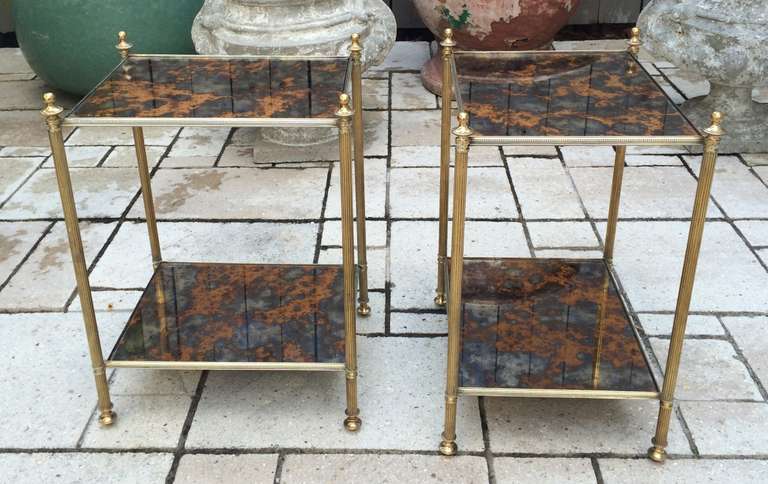 Fine quality pair of Bagues two-tiered end tables with beautiful églomisé mirrored tops. Detailing includes bronze finials and beaded frame.