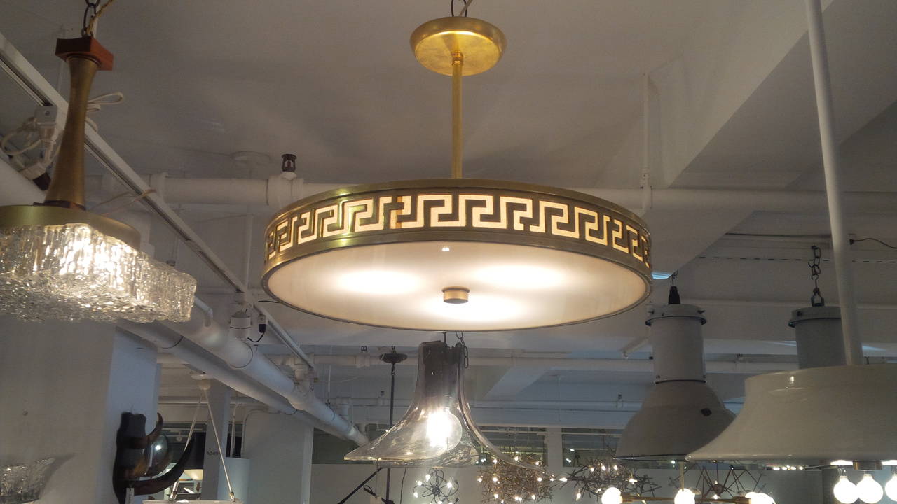 An exceptional circular light fixture with Greek key design. Lacquered bronze with frosted diffuser. France, circa 1960. Available as pedant light fixture (as shown) or flush mount.  Newly rewired.  Takes three standard U.S. bulbs, 60 watts max
