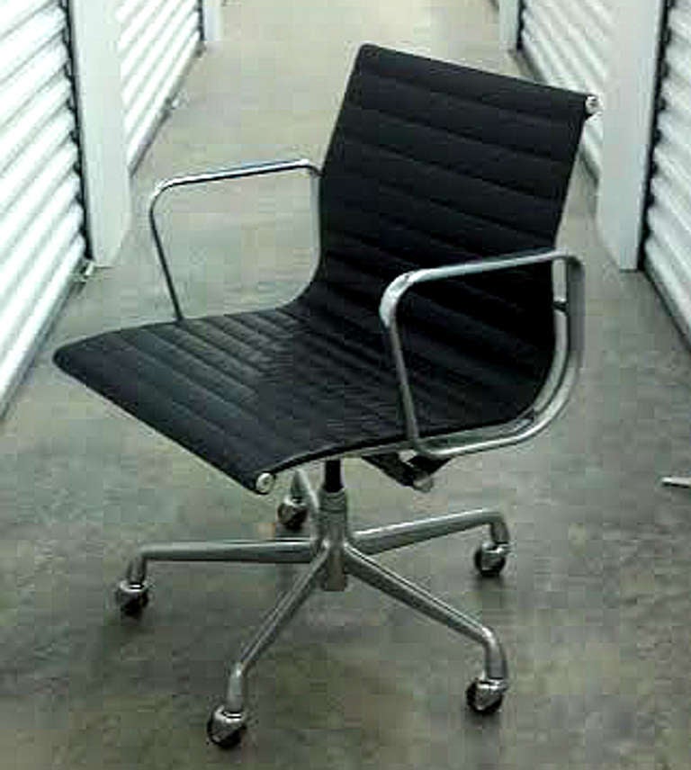 Set of six (6) Eames Aluminum Group desk chairs on a five-star, swiveling, rocking, rolling base with matching arms, in black leather. Manufactured by the Herman Miller Furniture Company. Seat height is adjustable. All chairs are sturdy and in full