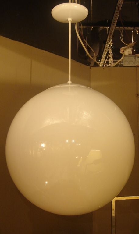 An acrylic globe hanging light fixture in the midcentury style. Originally designed and made by Lightolier, these lamps were a signature light fixture in early Eichler residences.
Features a large globe with a metal painted ceiling mount; see below