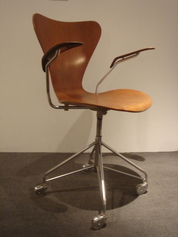 Series 8 Model Desk armchair by Arne Jacobsen for Fritz Hansen.  Denmark, circa 1960.  Molded teak seat with polished metal swivel and adjustable height castor base.  Partial foil label.  Item may be viewed at the 1stdibs NYDC  showroom.