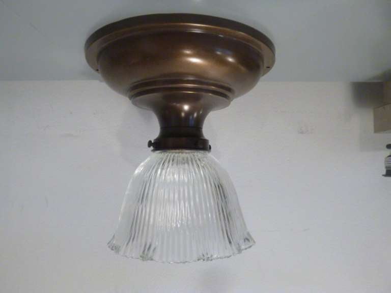 Vintage bronzed brass, flush-mount light fixture with fluted glass shade.  USA, circa 1920.