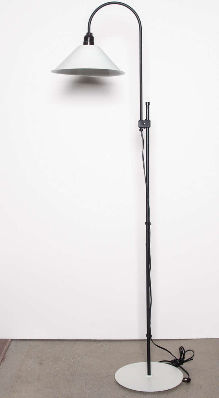 Minimalist adjustable-height metal floor lamp with white shade and round disc base complemented by black stem and hardware.  USA, circa 1970.