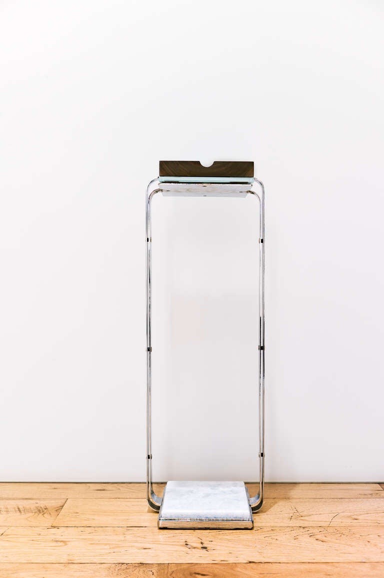 The number one ashtray was designed as a cigar ashtray to be used while in the seated position. Ribbons of polished chrome support a crystal ashtray, creating a minimal profile when viewed from the side. The base of the stand houses a solid block of