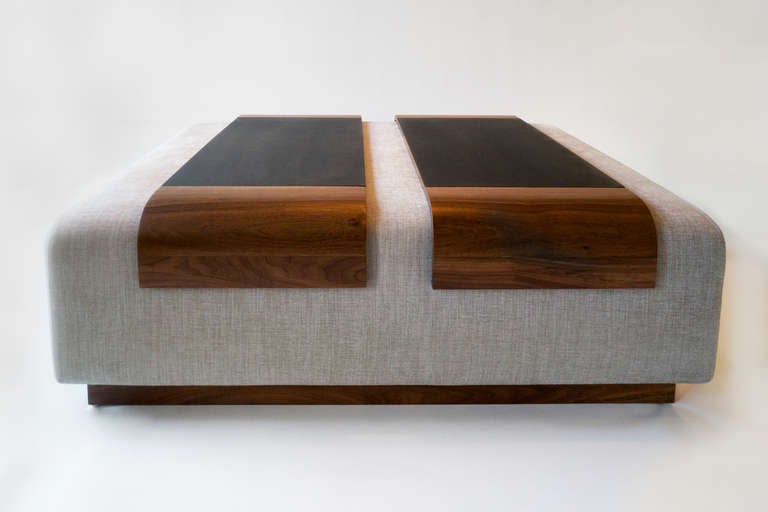 Large upholstered ottoman with single ottoman tray. Walnut wood accents at base and tray with contrasting blackened steel inlay.