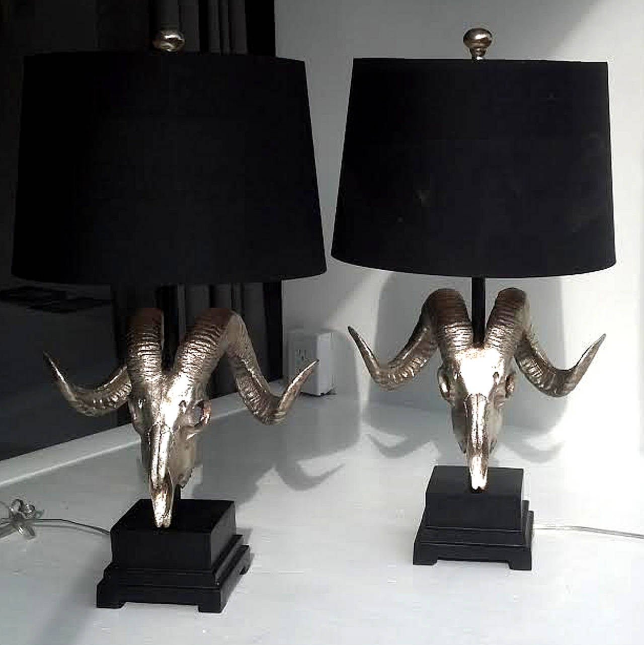 Pair of gilt ram skull form lamps. These are made from cast and gilded resin. They are very dramatic and very chic.
27inches tall overall, 14 inches to the top of the horns. The base is 6in. x6in. with the skull being 10inches deep and and 16
