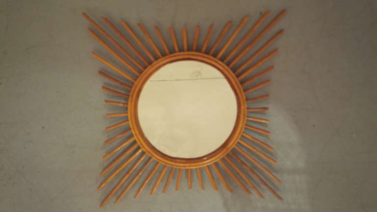 Rattan starburst mirror. France, circa 1960.

Beautifully crafted mirror with rattan frame and rays.