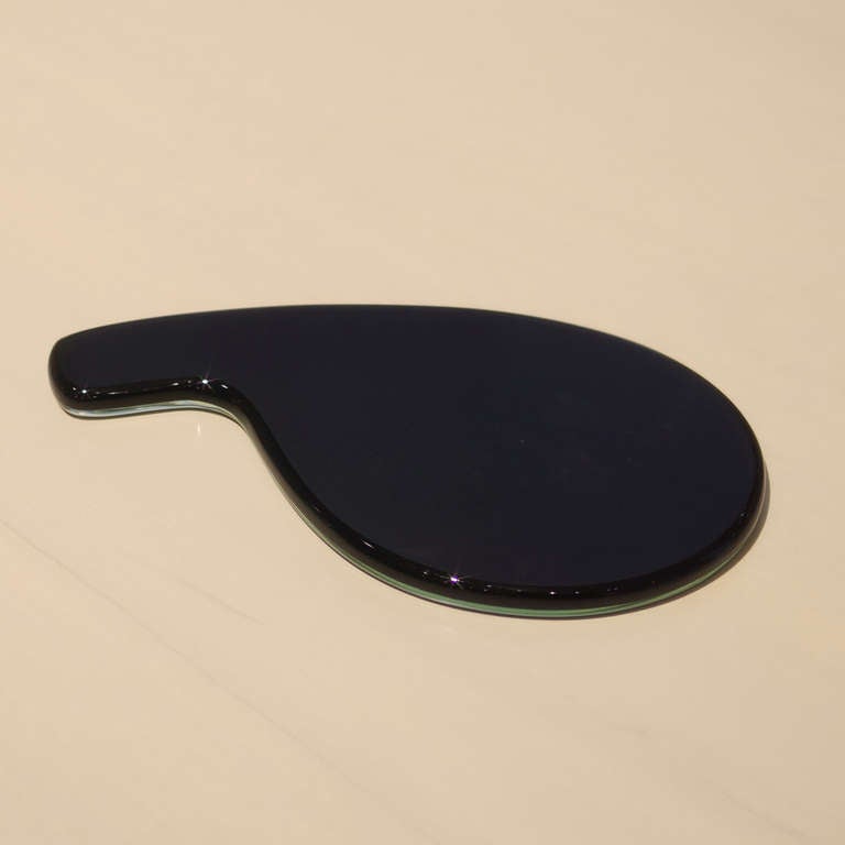 Hand mirror designed by Gio Ponti for Fontana Arte. Black glass bonded to mirrored glass. Designed in 1932, executed in 1961. Measure: Mirror is 9