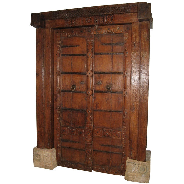Beautifully hand carved haveli door with frame from Gujarat, India. Solid wood with iron hardmounts and original stone base. This set of doors was used as an entrance to a palatial home in southern India. Assembly required. 