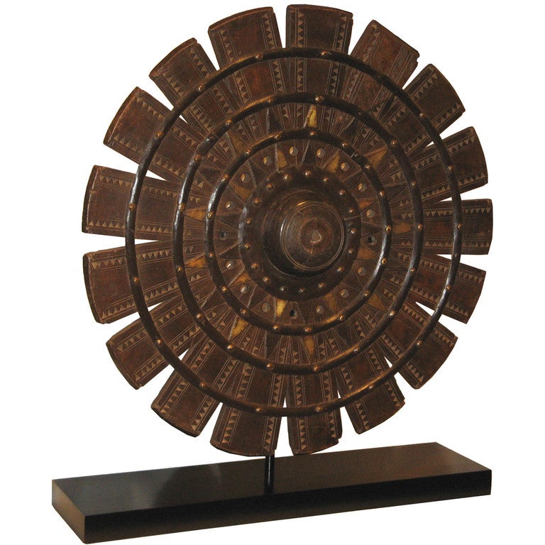 Vintage teak wood weaving wheel from northern India. With brass and iron hardmounts and mounted on a black wood stand. 