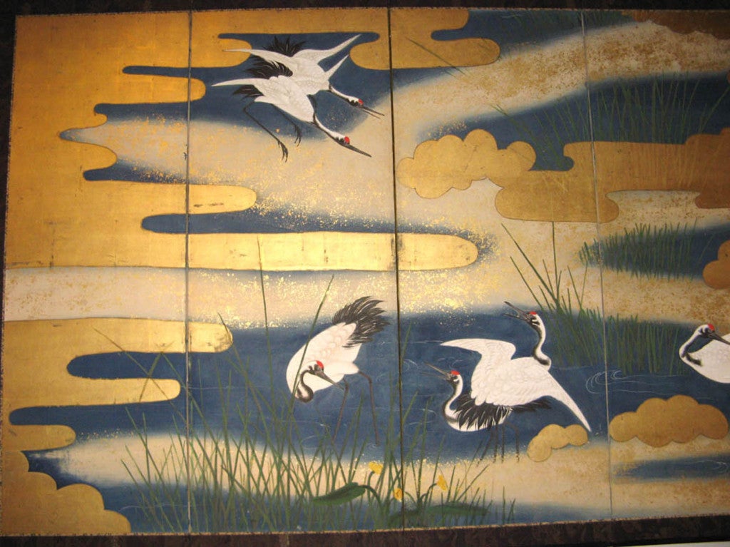 This exquisite and classic Japanese screen from Kyoto is of the Kano school, circa 1880. Made with rice paper and gold leaf showing cranes flying along grass and into the sky and clouds. Silk brocade along the edges, with black lacquer wood frame.