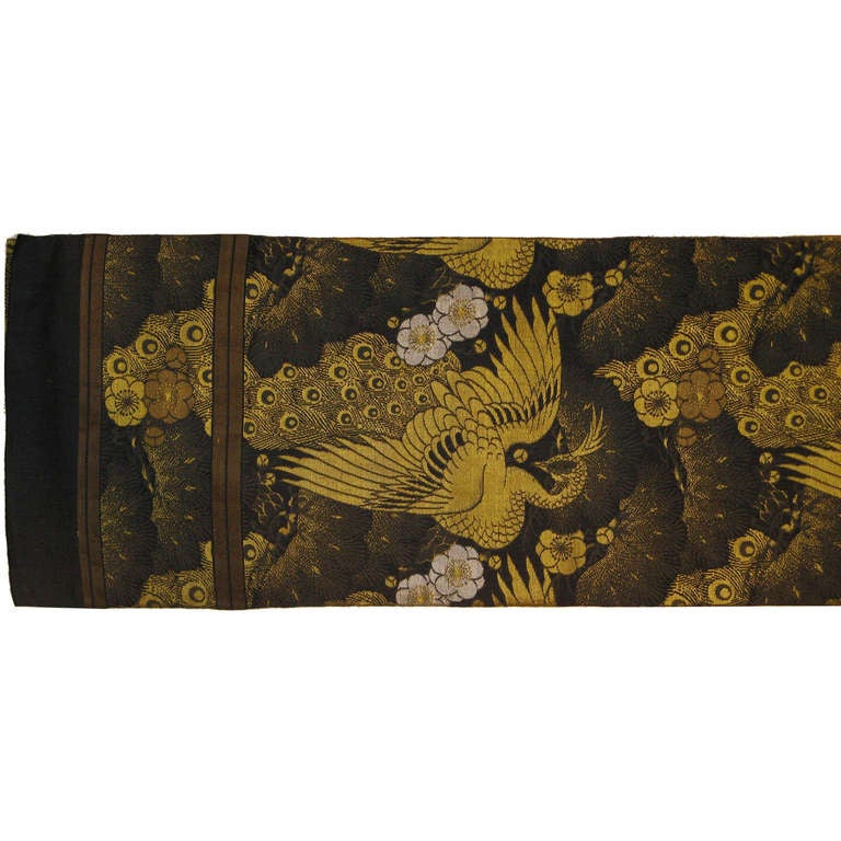 Antique Japanese maru silk brocade obi from Kyoto. Meiji period, circa 1880s. Patterned on both sides with heavy gold threading depicting peacocks and cherry blossoms in a pine forest. It can be used as a table runner or as a wall hanging.