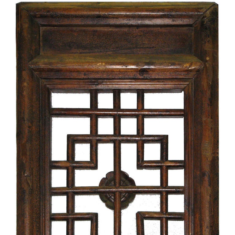 Pair of hand-carved wooden doors from China's Shanxi province with geometric patterns on the top. Can be hinged together for use as a room divider.