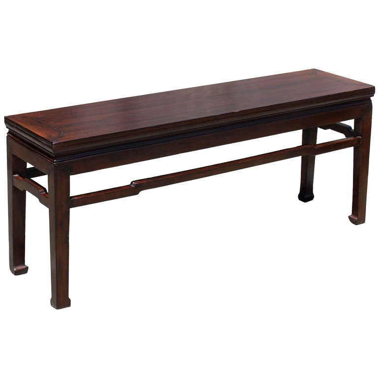 Classic elm bench in rich brown lacquer finish with recessed waist, horse hoof feet and humpback support stretchers. Use at the foot of a bed or for seating. Circa 1890s.
