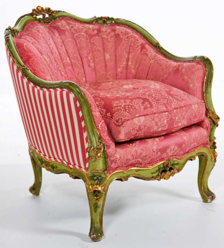 A chic pair of carved painted and gilt Venetian upholstered arm chairs, club chairs, or known as bergeres.  These are variations on a style first popular during the reign of Louis XV in the mid 18th century.  These chairs where made early in the