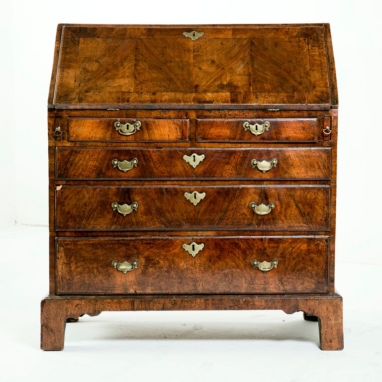 A nice slightly rustic Classic George II walnut slant front desk made in England, circa 1730. The color is very nice and the pagination is good. The interior is elaborately fitted with stepped serpentine drawers, hidden compartments, hidden drawers