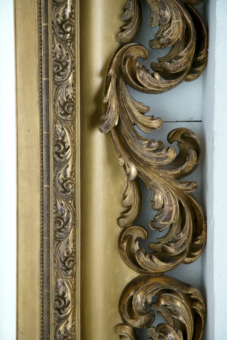 An unusually large Italian Baroque style giltwood mirror frame made during the second half of the 19th century. Originally a painting frame. Now an enormous and very elaborate mirror. Photographed in its' moving crate.