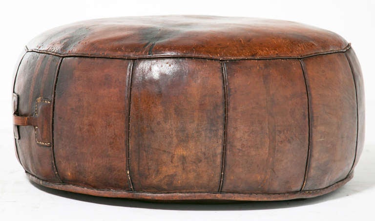 A wonderful worn round leather ottoman probably made from the 1920's.
