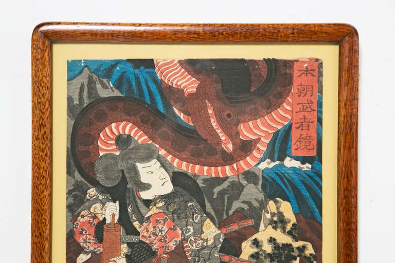 A wonderful and brillant Japanese wood block print featuring Jiraiya loading his gun.  Depicted with a spotted frog and a coiling snake.  Made early in the Meji Period.