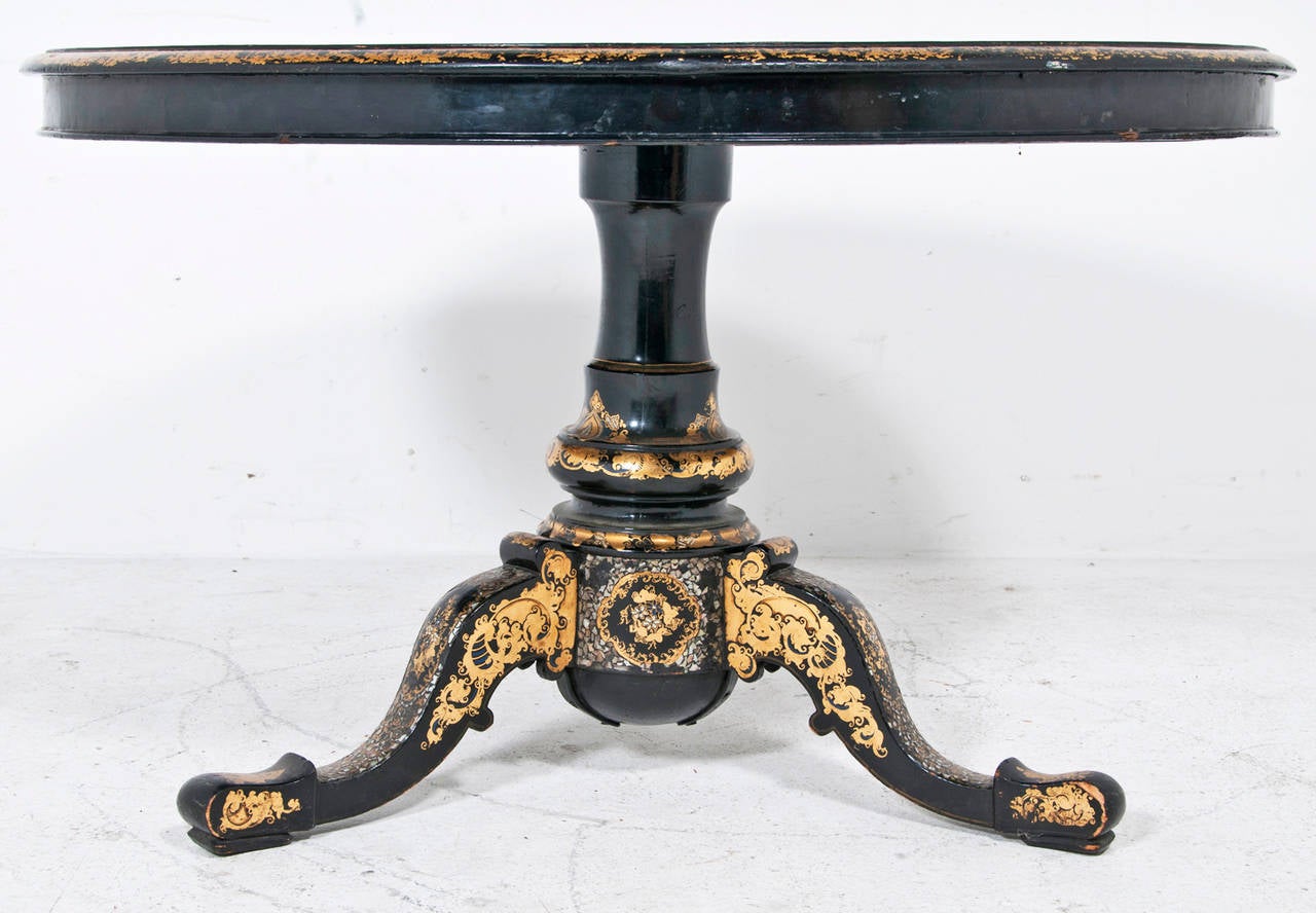 This large and beautiful English Victorian center table made circa 1860 is richly decorated with gilding, lacquer inlaid shell and decorative floral painting. It comes to us from a collection formed early in the 20th century. The size and condition