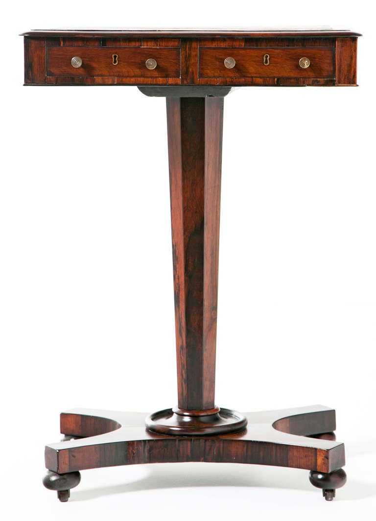 A rare and useful English Regency period rosewood pedestal with inset tooled leather and two drawers. We think this was made somewhere in the United Kingdom during the first part of the 19th century. Finished on four sides so this small table would