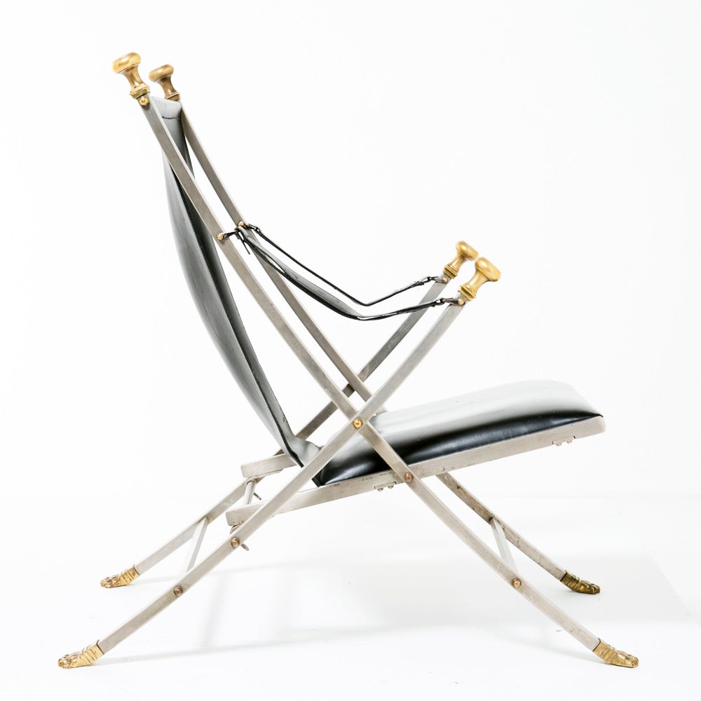 A very elegant assembled pair of similar Campaign chairs by the famous French firm Jansen. Upholstered in leather on frames of brushed steel and brass with slight variations in detail which makes us think one chair is most probably slightly older.