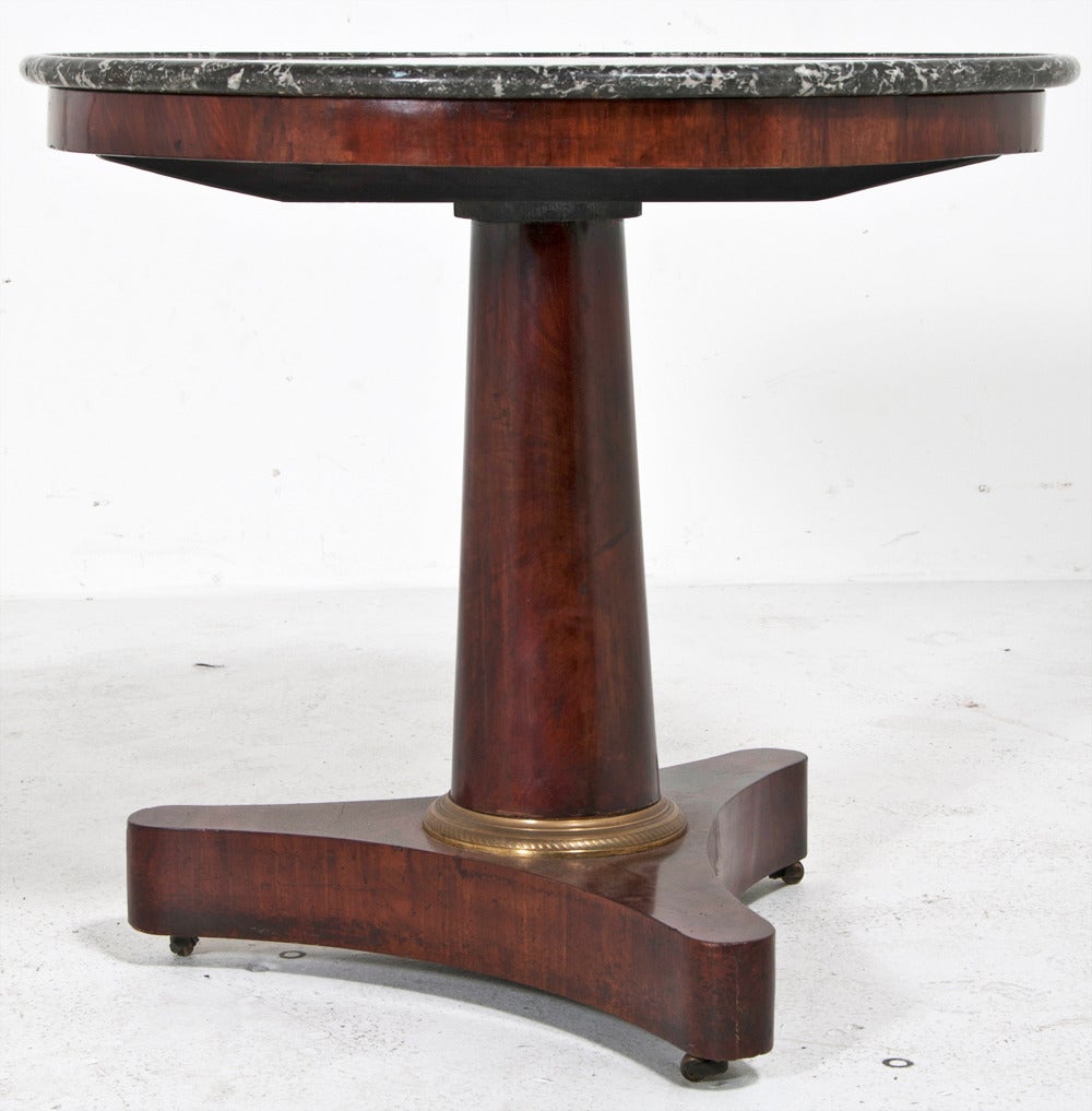 A nice early 19th century French Louis Philippe period Gueridon or center table with marble top and gilt metal accents.  This piece is mahogany and has had some restoration.   Perfect piece for a small entry hall, office, small dining table, or side