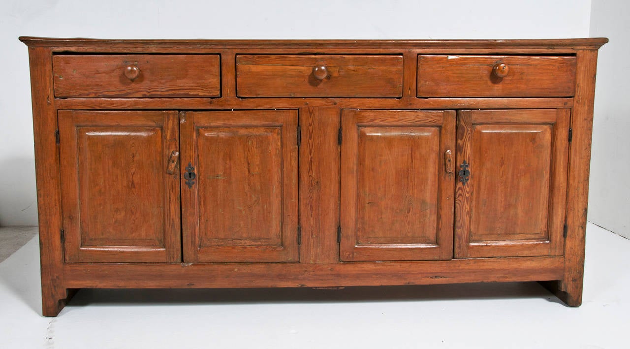 A nice Provincial Irish pine dresser base made during the first half of the 19th century. A useful rustic piece with lots of character and storage. Some traces of earlier paint.