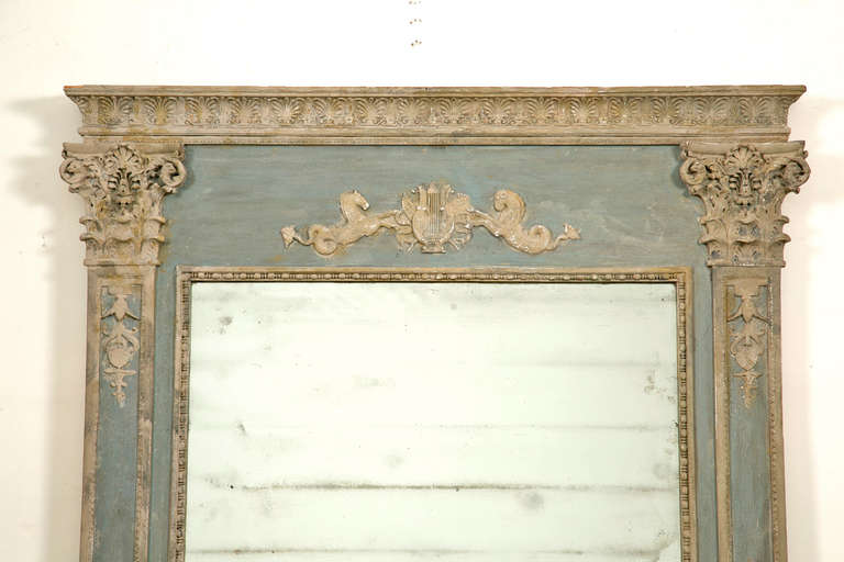 A late 19th century painted Continental trumeau. The relief on the top features a hippocampus, "Water Horse" facing each other flanking a lyre.