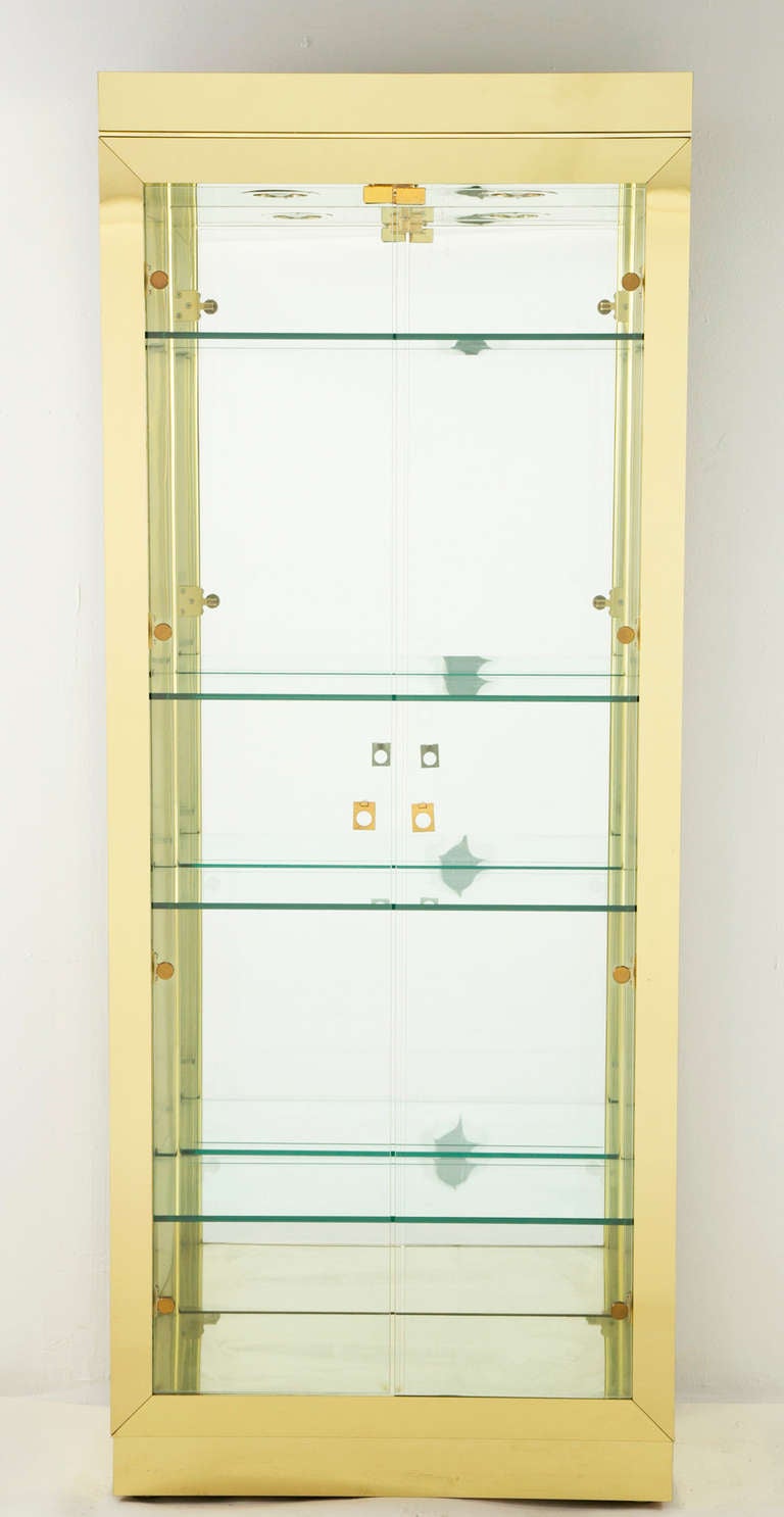 A handsome glass vitrine attributed to Mastercraft. We think these date to the 1970s. The shelves have an engraved or beveled edge so that plates can lean.  Vitrines integrate lights and dimmers. This is not what we generally handle. This piece is