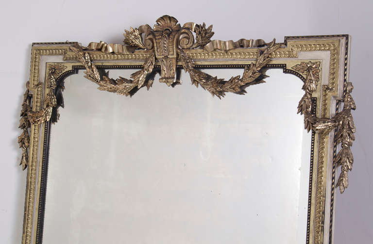 A large and elegant late 1th Century French silver gilt mirror with painted accents. 

Condition: Some repairs to carving and gilding. Painted surface later. Some oxidation to mirror plate