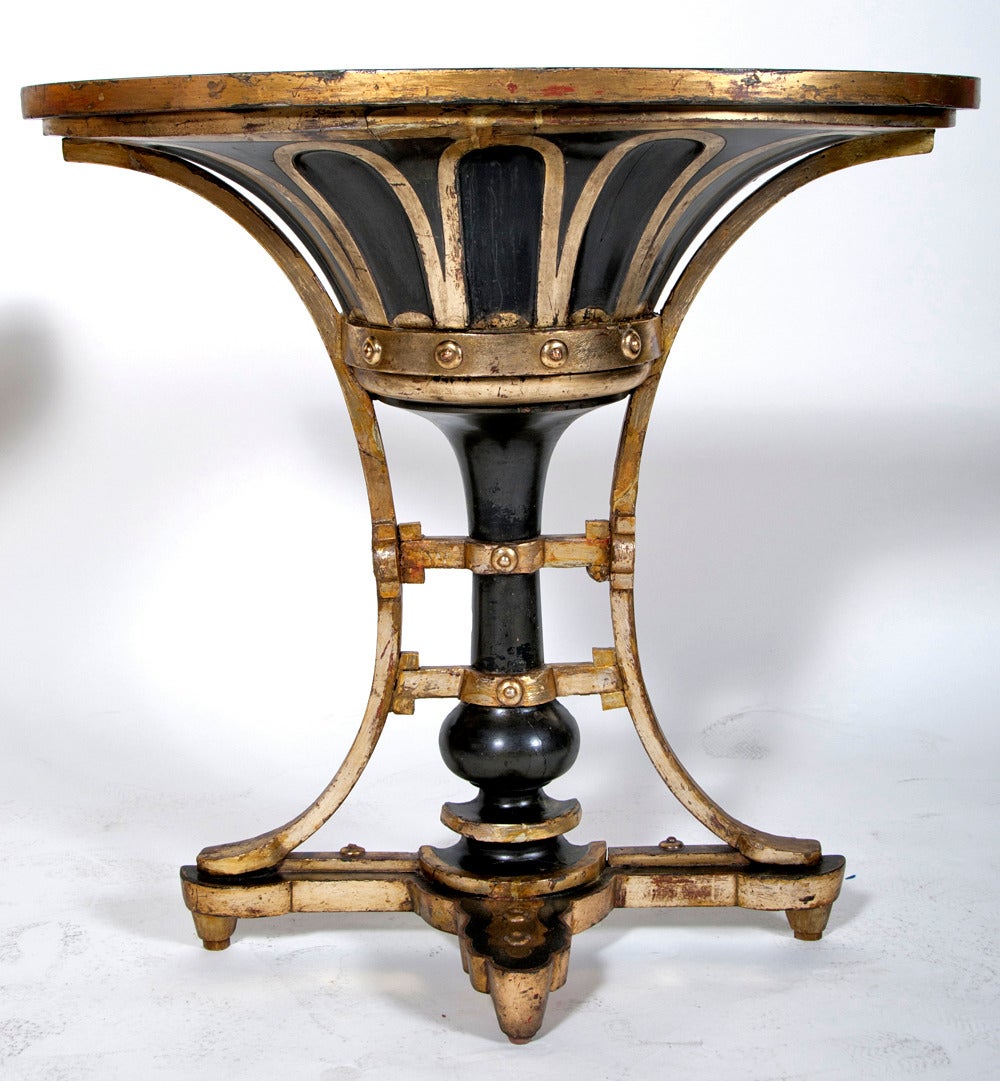 A chic chocolate painted and mecca gilt consoles. Interesting almost industrial design with carved and gilt rivets. Highlighted with mecca, silver water gilding with a lightly gold toned varnish. The tops fold open to reveal red painted tole