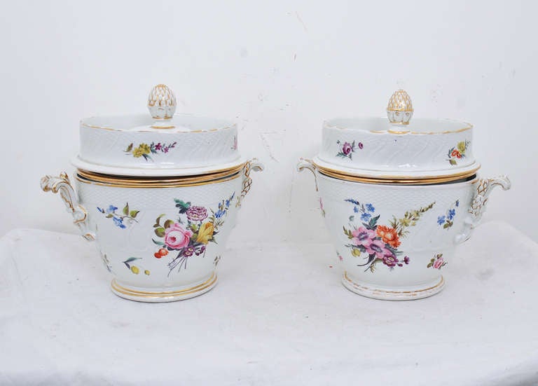 Because of the size and rarity, pairs of fruit coolers are extremely rare. Ice was placed in the rim and base. The fruit rested in a bowl suspended in the middle. These are decorated in gilding with sprays of flowers. We think they are probably