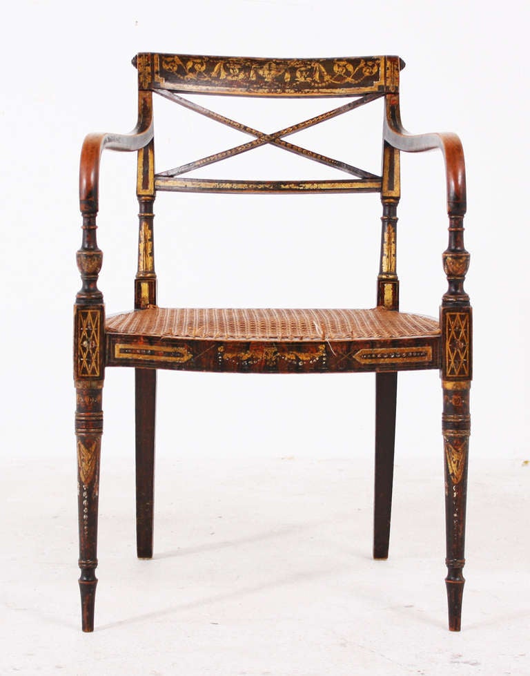 A rare, sophisticated and useful pair of English armchairs made during the early 19th century during the Regency period.  These are particularly desirable because the have original paint and gilt decoration done in the 