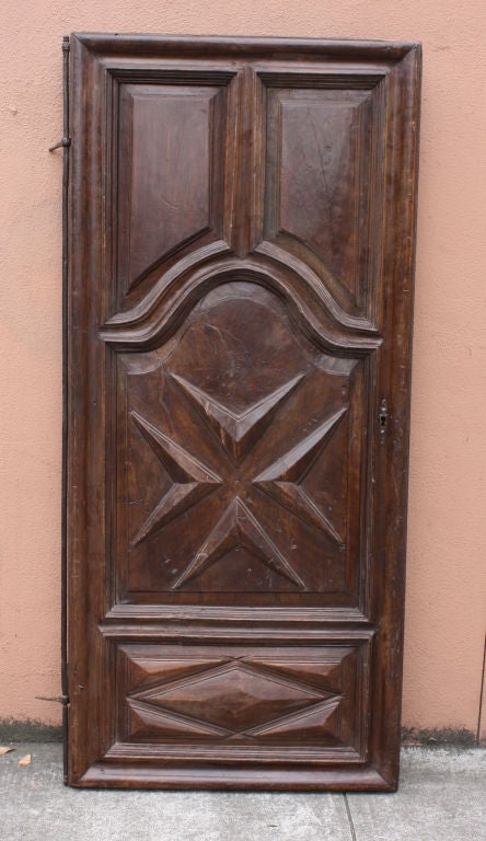 A handsome walnut door featuring raised molded paneling and a Maltese cross made in France or Italy during the 18th century, the door includes its period steel hinge.