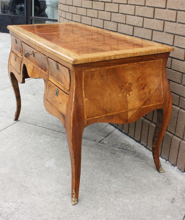 A handsome inlaid fruitwood desk made in Italy during the 19th century.  This would be great as a desk, side table or dressing table.  Wonderful curved profile.  Nice warm light color.