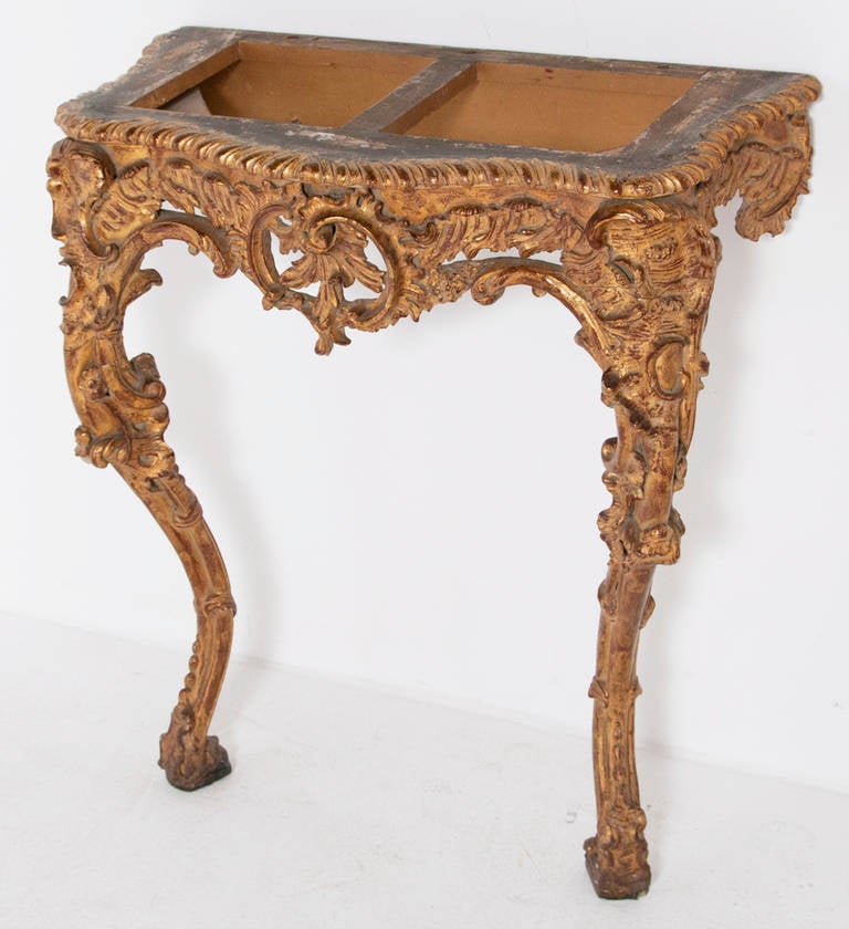 A small-scale late 19th early 20th century Italian Rococo style giltwood wall mount console with a black slate top. The serpentine top over a pierced rocaille carved apron raised on acanthus carved cabriole legs. The slate top decorated with painted