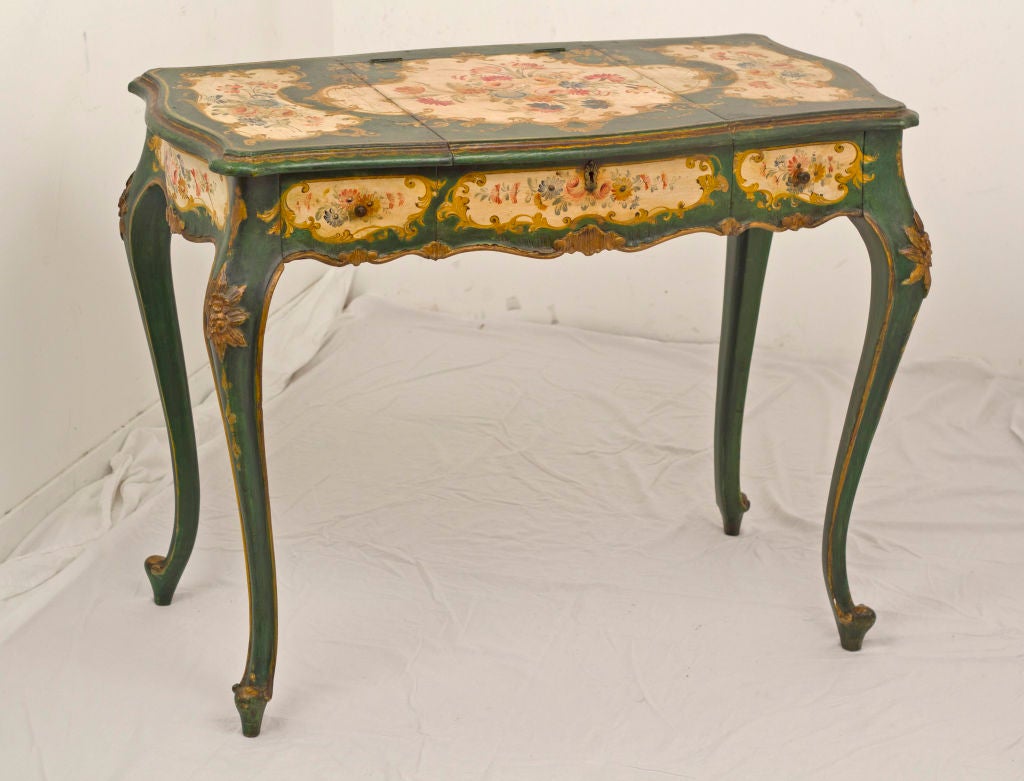 An elegant Italian Venetian Dressing Table / Desk made late in the 19th century in the mid 18th century style.  This piece features substantially original decoration on a rich green ground.  This table would float nicely in the middle of a room.