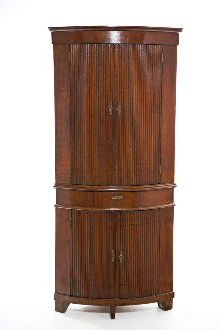 A nice provincial Gustavian corner cupboard or cabinet made in Sweden or Denmark about 200 years ago.  The design reflects Neoclassical style that was so fashionable from about 1780 till 1830.  The fluted doors are a nice feature that adds interest.