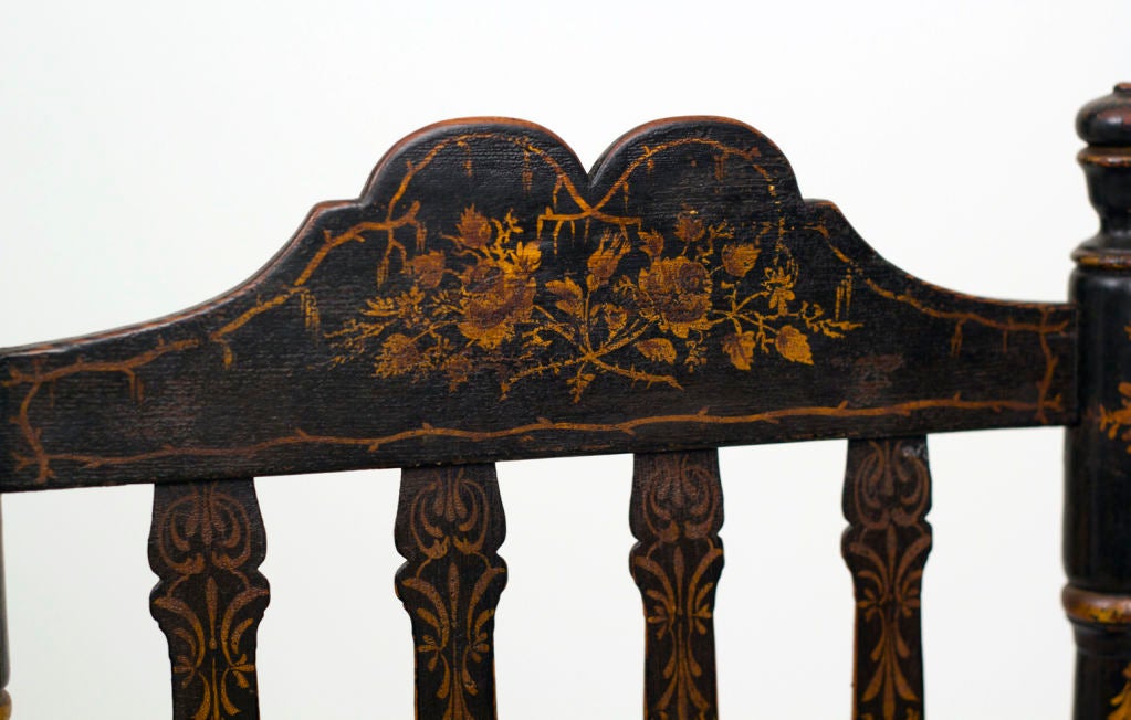 A nice small scaled black painted rocking chair decorated in gilt with seaweed and flowers.
