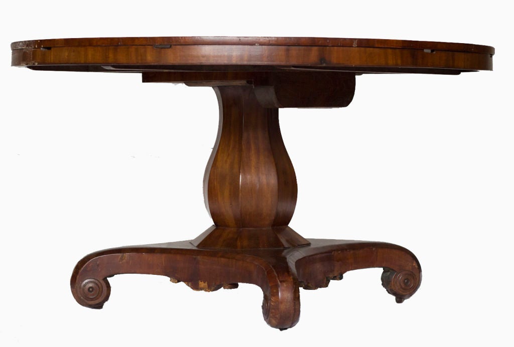 A very rare expandable Jupe style mahogany pedestal dining table made in England during the second quarter of the 19th century, with four original mahogany leaves.  The table is 29