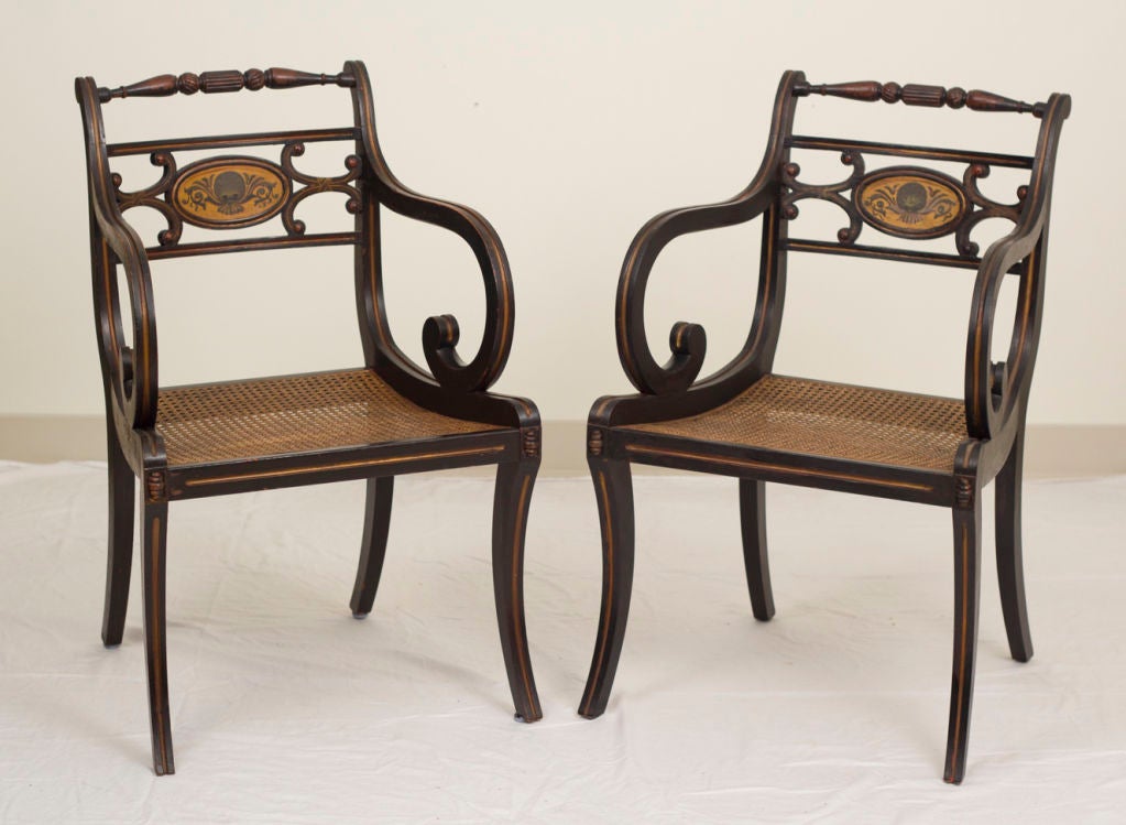An elegant ebonized fancy painted armchair in the Regency Style. Made in England during the first quarter of the 20th century. 
