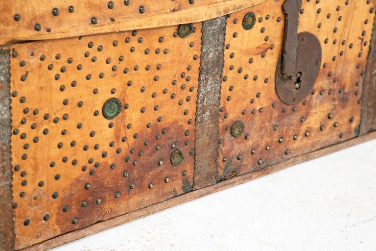 A handsome, rustic large scaled trunk made in colonial Mexico or Peru during the 19th century. This wonderfully whimsical piece with its mass of tack decoration, humped top with a rare top hinge opening and warm color would look great at the end of