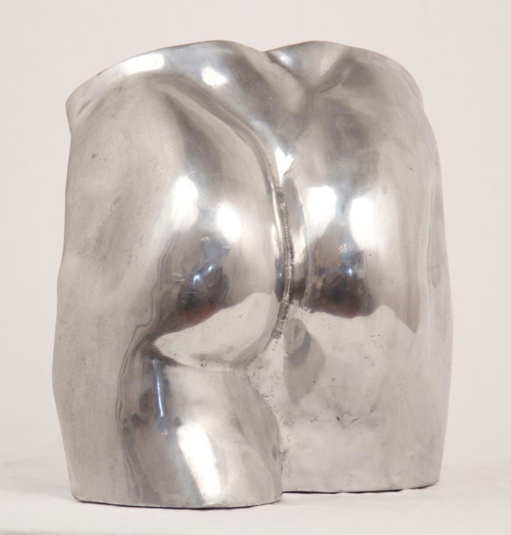 A quirky cast aluminum sculpture of a muscular posterior.  Slightly less than life size.