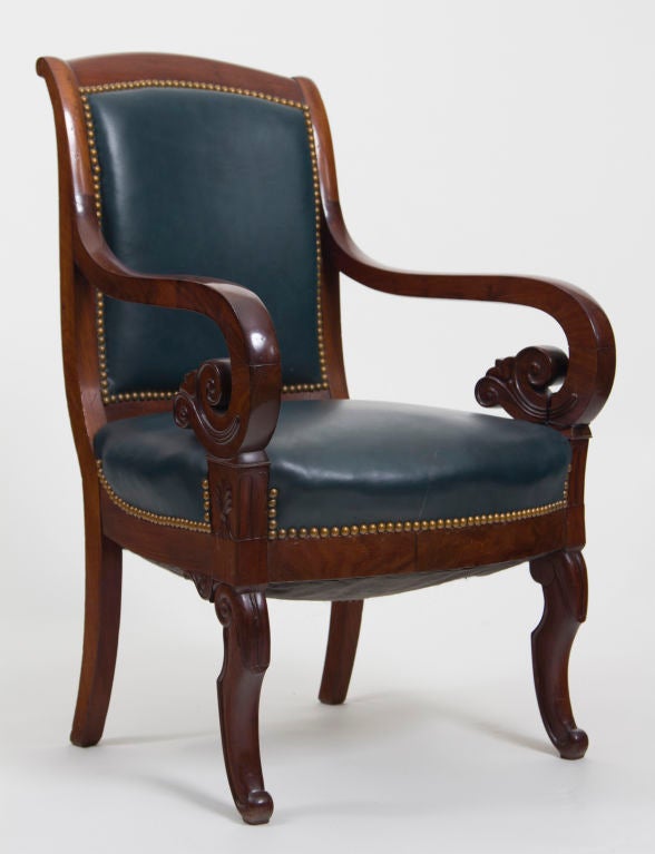 A chic set of six antique French mahogany armchairs upholstered in navy blue leather with brass nailhead trim. From a very good collection, 19th century.